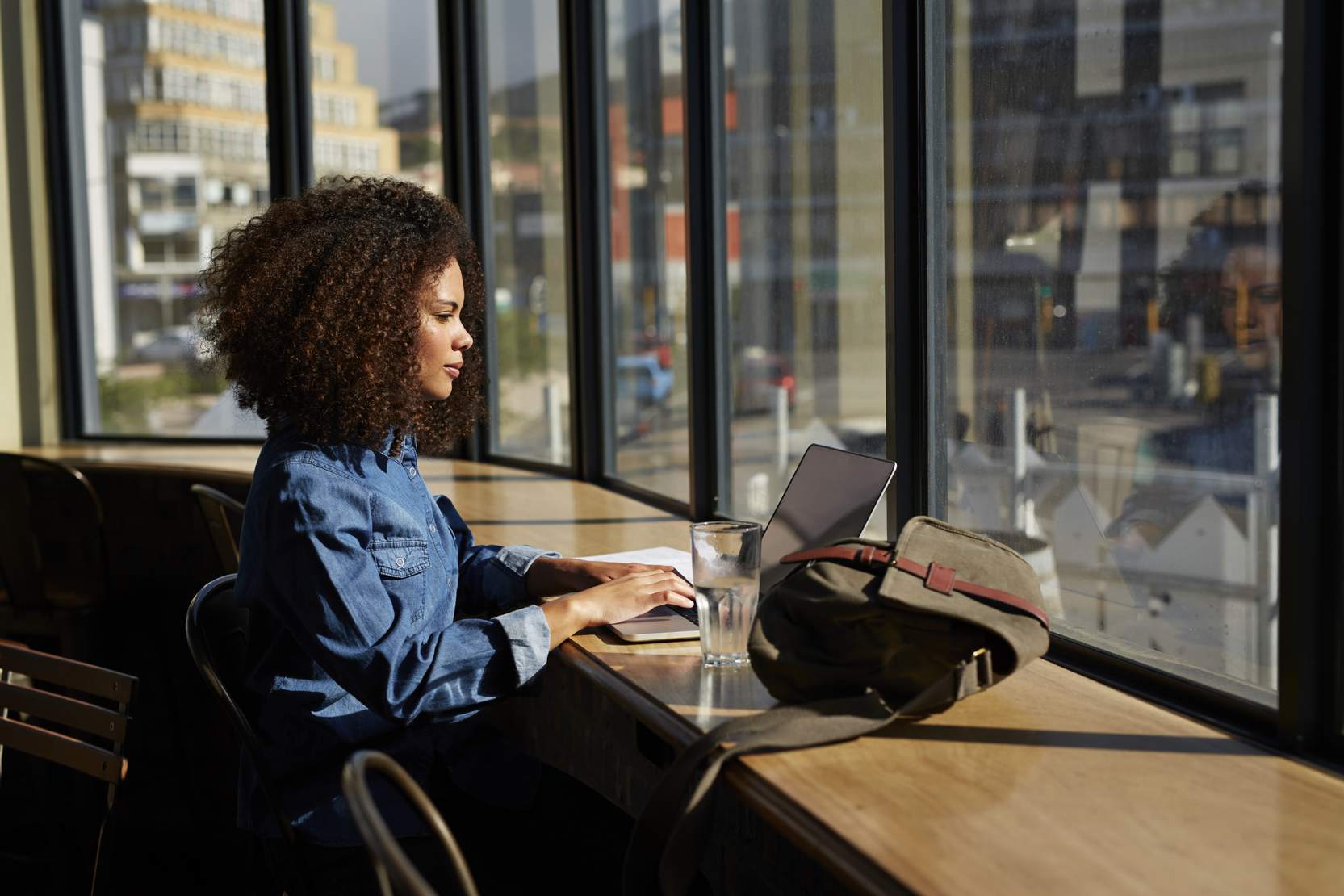 woman-using-laptop-at-cafe-at-sunset
